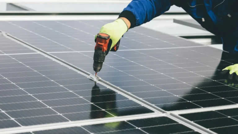 Arbeiter befestigt ein Solarmodul mit dem Akkuschrauber